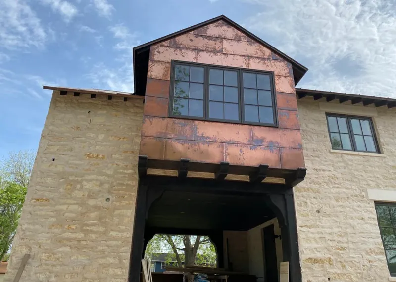 Copper metal panel facade on a stone building for Roof Repair in Sulphur
